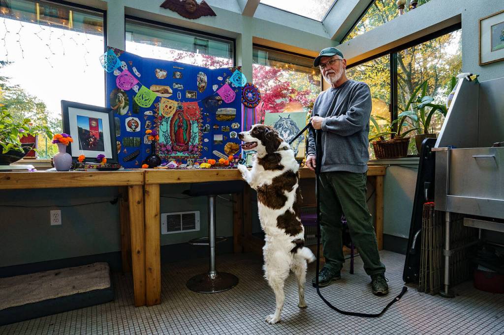 Photo by David Welton
Tim Tuttle and his dog Jasper celebrate Dia de los Muertos at Georgia Edwards home in Clinton. Edwards builds an altar to honor deceased pets every year.