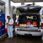 Photo by David Welton
Alfredo Herrera fills gas cans for his generator during power outages over the weekend.