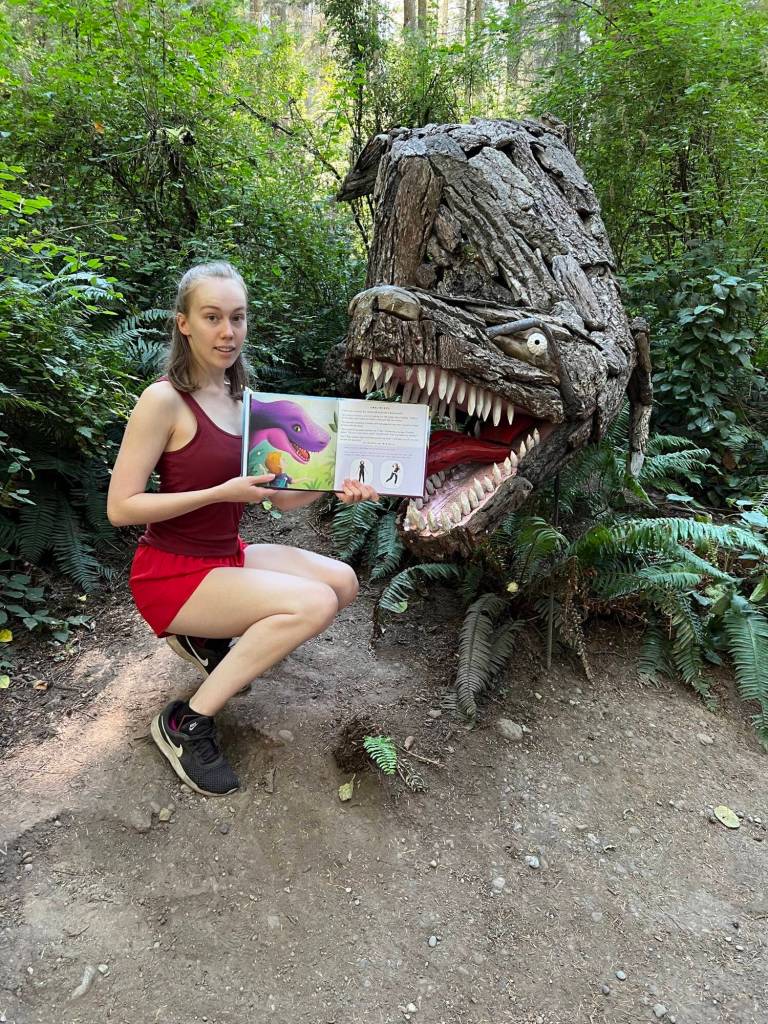 Kaelyn Lefferts with Joe Treats driftwood T-rex sculpture in the Price Sculpture Forest. (Photo provided)