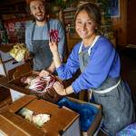 Max Dornbush and Courtney Storer unpack fresh veggies and greens from the Whidbey Island Grown Cooperative. (Photo by David Welton)