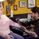 Photo by Rachel Rosen/Whidbey News-Times
Kyle-John McKenzie, who recently moved from South Africa, tattoos a floral piece on Jessica Broadfield.