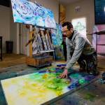 From the floor, Cormac McCarthy demonstrates his technique for mixing together paint colors on an additional canvas, which he uses as a giant palette.