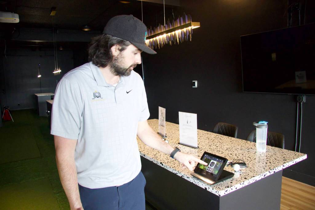 Photo by Rachel Rosen/Whidbey News-Times
Ray demonstrates how to use the golf simulator technology.