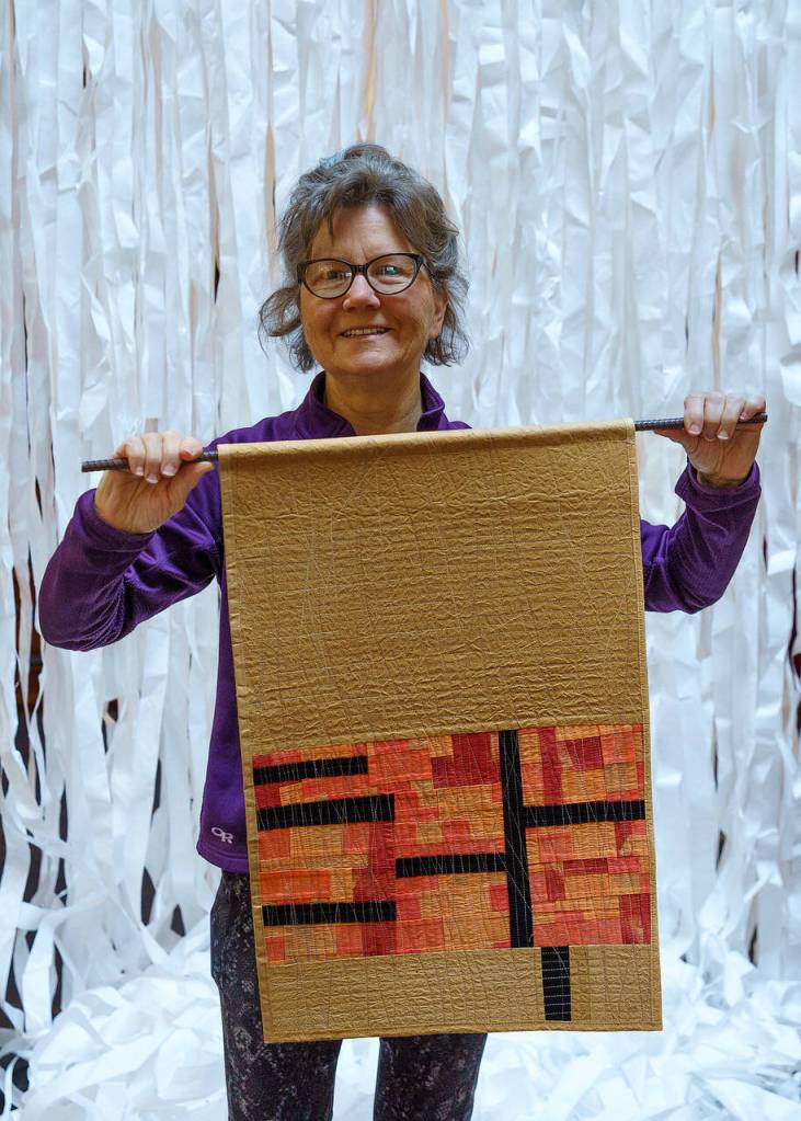Photos by David Welton
Laura Stangel Schmidt with Interior Monologue, an art quilt interspersed with brown paper bags.