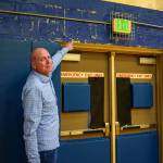 South Whidbey High School Principal John Patton points out water damage on the cinder block walls of the gym. (Photo by David Welton)