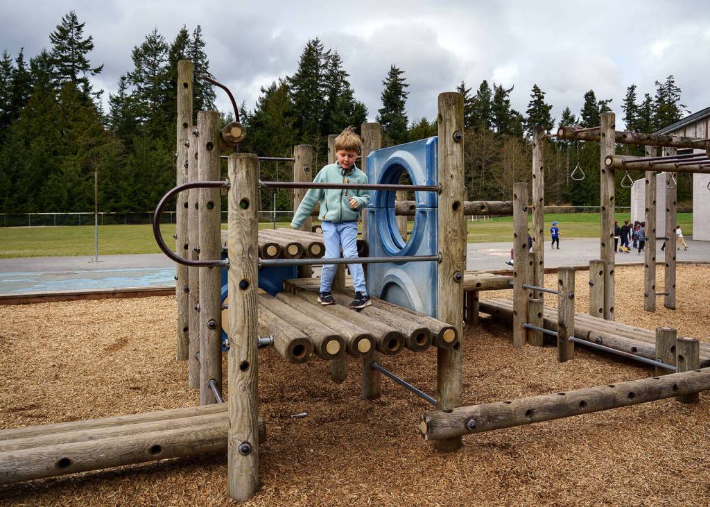 Kindergartener Nicolas Bent plays on an outdated wooden structure at South Whidbey Elementary School North Campus. The proposed bond would provide brand-new inclusive equipment thats accessible to kids of all abilities. (Photo by David Welton)