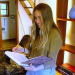 Development and Communications Specialist Nia Martin pages through a journal in one of the Hedgebrook cottages. (Photo by Kira Erickson/South Whidbey Record)