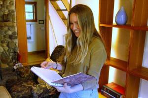 Development and Communications Specialist Nia Martin pages through a journal in one of the Hedgebrook cottages. (Photo by Kira Erickson/South Whidbey Record)