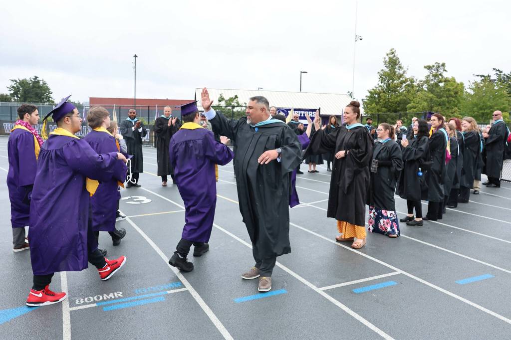 Oak Harbor High School graduates hand out high-fives during the ceremony. (Photo by John Fisken)