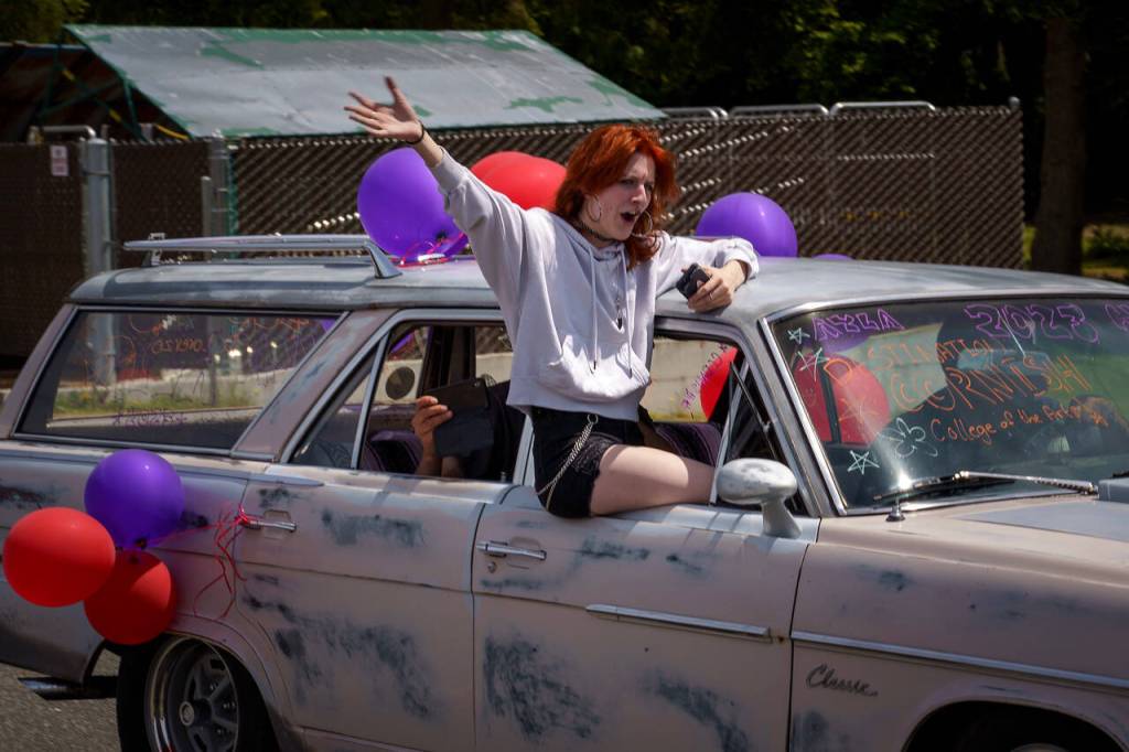 Ayla Di Lorenzo waves from a car during a parade last week for South Whidbey High School graduates. (Photo by David Welton)