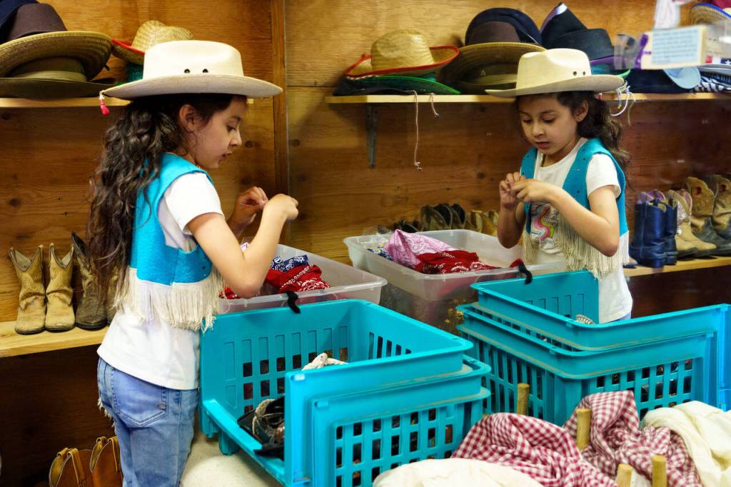 Second grader Athena Guerrero tries on accessories from the ranchs spacious closet. (Photo by David Welton)
