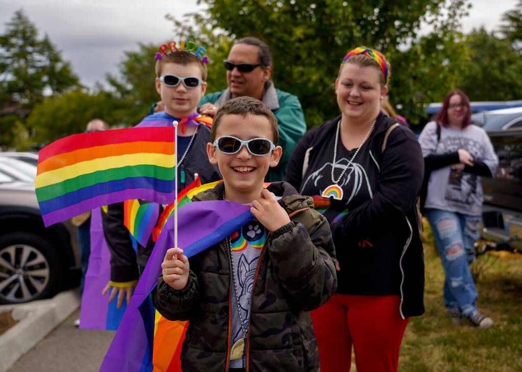 Conner Hampton, center, walks in the Coupeville Pride Parade with his brother, Corbin; his father, Larry; and his mother, Sara. (Photo by David Welton)