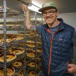 Joe Gunn with a rack of freshly baked pies in the cooling room of the Whidbey Pies production facility. (Photo by David Welton)