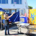 Chelsea Kawi celebrates as she successfully hits the target, causing Rep. Dave Paul to fall into the tank. (Photo by Luisa Loi)