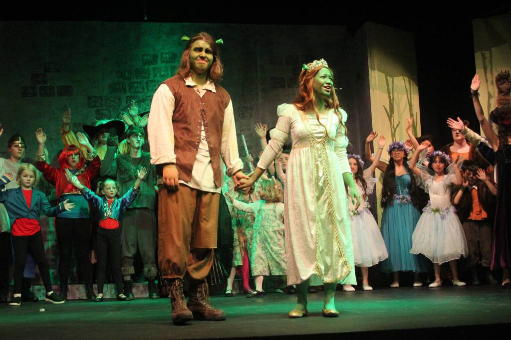Photo by Karina Andrew/Whidbey News-Times
Reconciled as ogres, Shrek, played by Graham Ray, and Princess Fiona, played by Dana Rivo, lead the cast of fairytale creatures and Duloc residents in the finale.