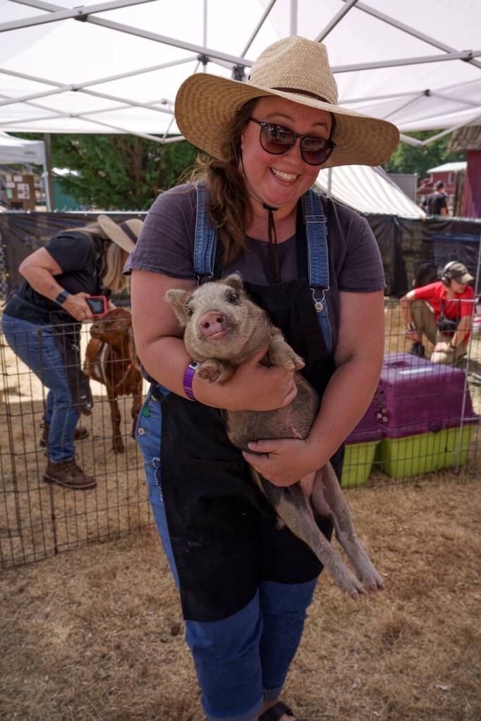 Mack Wright holds piglet Sage. (Photo by David Welton)