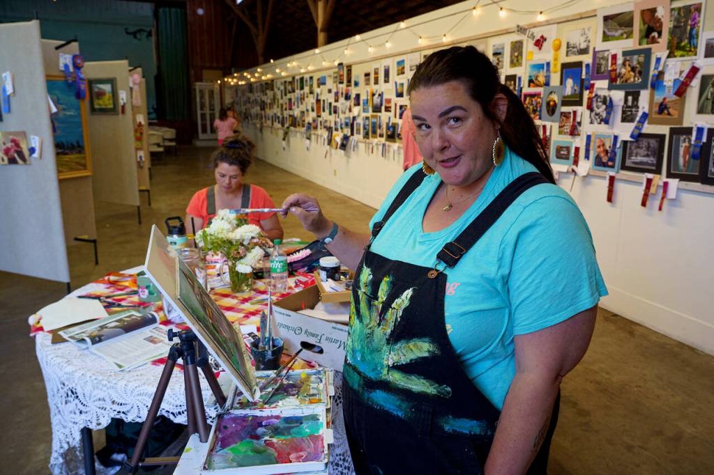 Meredith Cannon works on a painting during the Whidbey Island Fair. (Photo by David Welton)