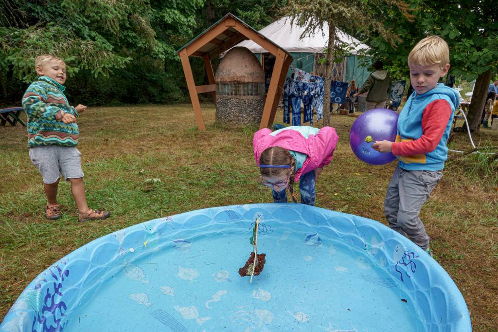 Photos by David Welton
7-year-old Katie Olin from Lynnwood sets her boat made from sticks and leaves afloat at Green Arts Camp Aug. 9.