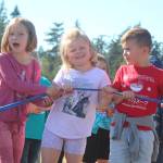 Photo by Karina Andrew/Whidbey News-Times
From left, first graders Amelia Rhodes, Chelsie Turner and Callum Macklin help hold the ribbon at the opening of the newly paved walking path at Hillcrest Elementary School Sept. 15.