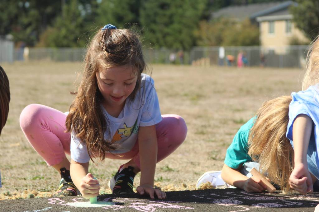 Photo by Karina Andrew/Whidbey News-Times
First grader Madilynn Davenport helps chalk the walk Sept. 15 at Hillcrest Elementary School.