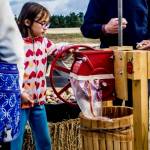 A girl helps press apples to make cider at one of the festivals earlier editions. (Photo provided)