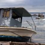 Photo by David Welton
On Tuesday morning, an abandoned boat was towed from the Clinton shore.