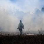 A firefighter walks across the smoky prairie. (Photo by Luisa Loi/Whidbey News-Times)