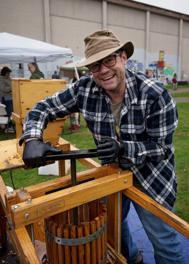 Scott Hogan, a Woodhaven High School parent, uses an apple press. (Photo by David Welton)