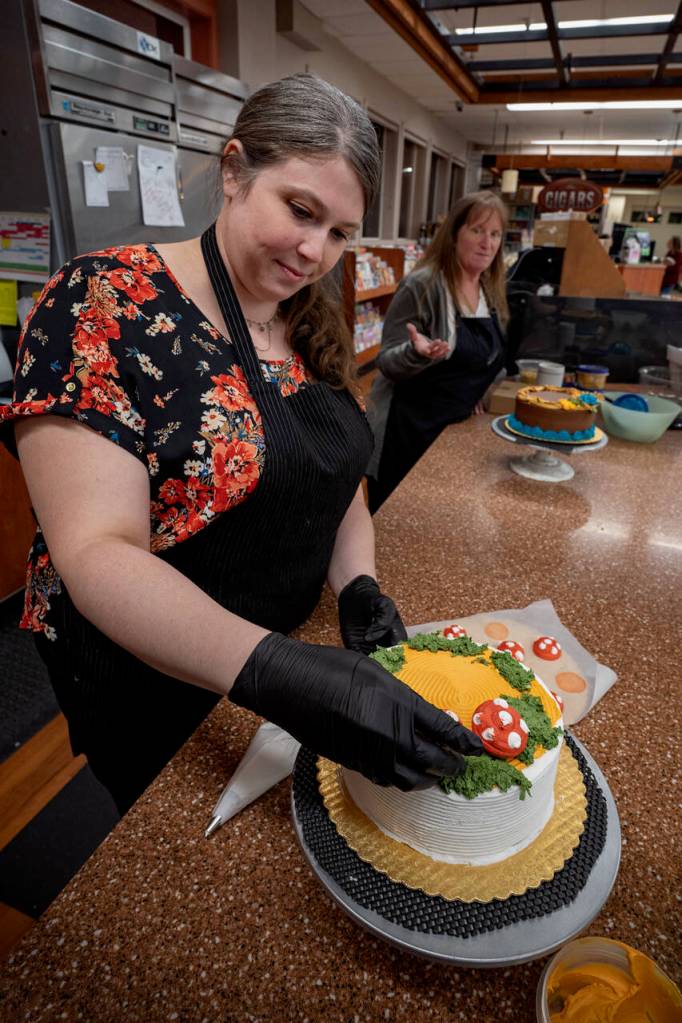 Photo by David Welton
Jennifer Holmes, left, places red-capped mushrooms made of buttercream frosting on her cake while Pia Stewart pipes with bright colors on her autumnal cake.