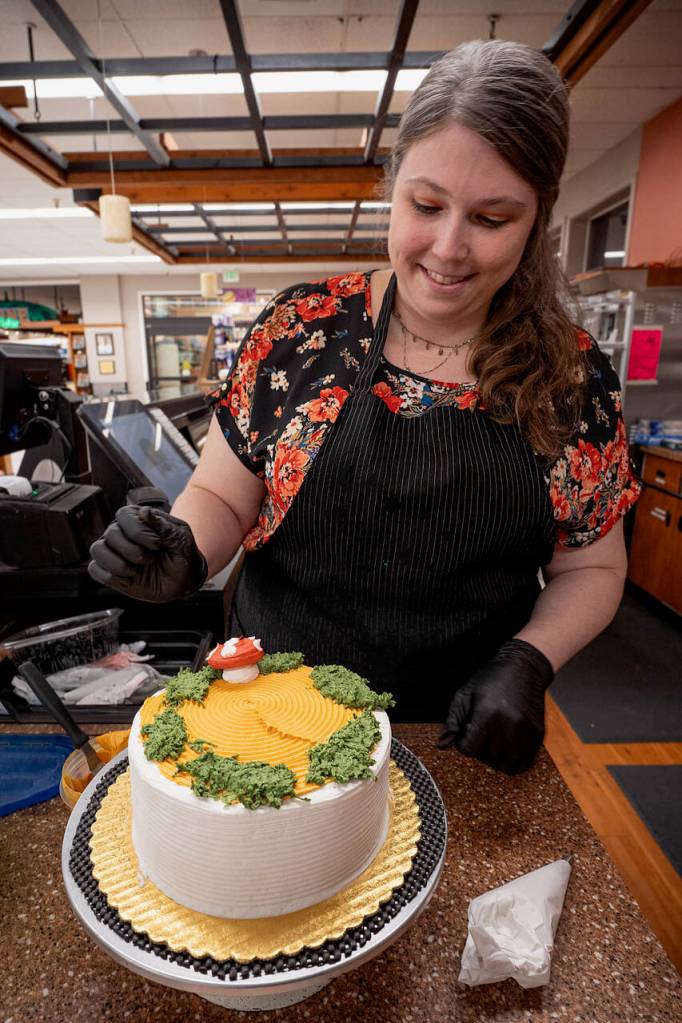Photo by David Welton
Jennifer Holmes places red-capped mushrooms made of buttercream frosting on her cake. Coconut mixed with green frosting gives the perfect mossy appearance.