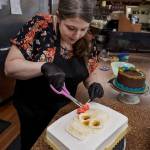 Photo by David Welton
Jennifer Holmes pipes a colorful flower crown for the La Catrina skull on her cake that has a Dia De Los Muertos theme.