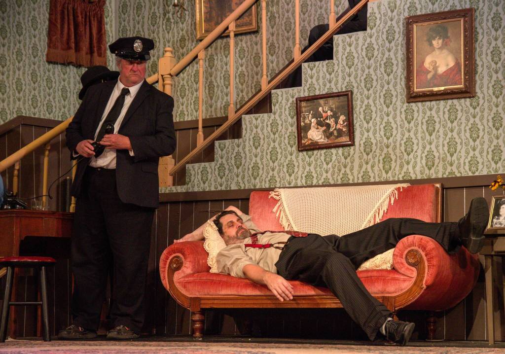 Fugitive Jonathan Brewster (played by Nate Edmiston) sleeps, unaware that Officer Brophy (played by Ron Wilhelm) is standing next to him. (Photo by Luisa Loi)