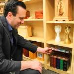Stucky shows a book-shaped cremation urn. (Photo by Luisa Loi/Whidbey News-Times)