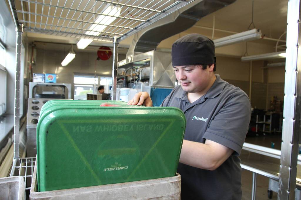 Timmy Aston dries off trays at the bases galley after sharing his extensive knowledge on video games and cartoons. (Photo by Luisa Loi)