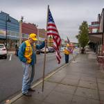 Tom Bond and Doug Jerome place flags on Pioneer Way. (Photo by David Welton)