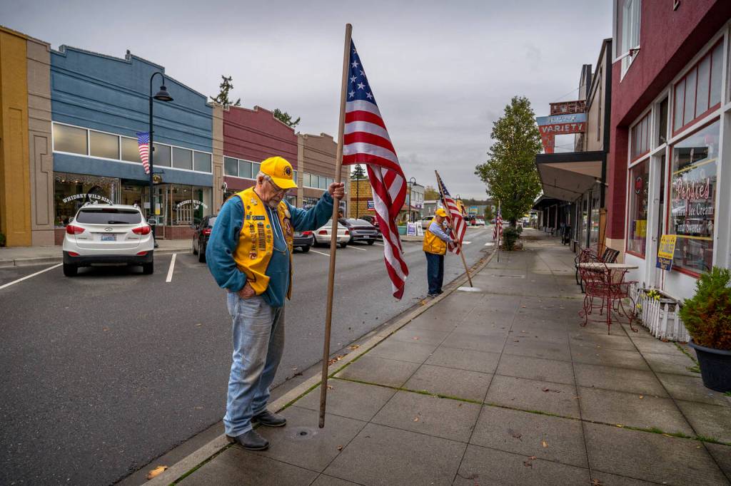 Tom Bond and Doug Jerome place flags on Pioneer Way. (Photo by David Welton)