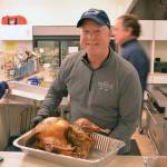Volunteer Mike Johnson brings out another turkey for carving during a past Thanksgiving. (Photo provided)
