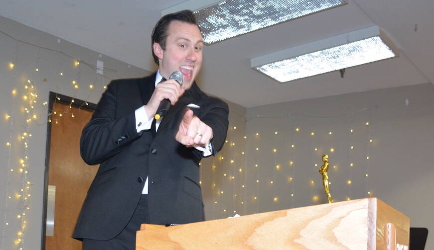 Master of Ceremonies Bryan Stucky points to some of his future customers. Stucky was awarded Best Businessperson of the Year and his business, Wallin-Stucky Funeral Home, won Best Business of the Year. (Photo by Megan Yerton)
