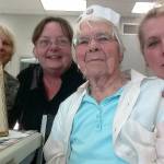 Erma Aldous, 99, shows her military portrait at a Whidbey Veterans Resource Center event. Surrounding her are volunteers Maggie Johns, at left, Kat Ersch and program coordinator Dana Sawyers. (Photo provided)