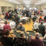 Residents feast and socialize at the community potluck at the Coupeville Rec Hall. (Photo provided)