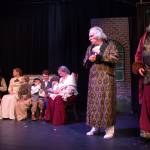 The Ghost of Christmas Present (Lachlan Waterbury) takes Scrooge (Ben Honeycutt) to the home of his clerk, Bob Cratchit (John Trent), who he had always treated poorly. (Photo by Luisa Loi)