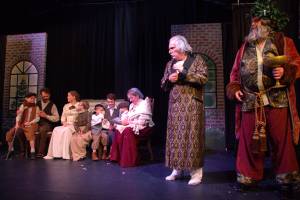 The Ghost of Christmas Present (Lachlan Waterbury) takes Scrooge (Ben Honeycutt) to the home of his clerk, Bob Cratchit (John Trent), who he had always treated poorly. (Photo by Luisa Loi)