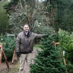 Isaiah Rawls poses with a tree at A Knot in Thymes tree farm. (Photo by Luisa Loi)