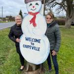Sandee Allen, left, and Vicky Reyes greet a Coupeville snowman.