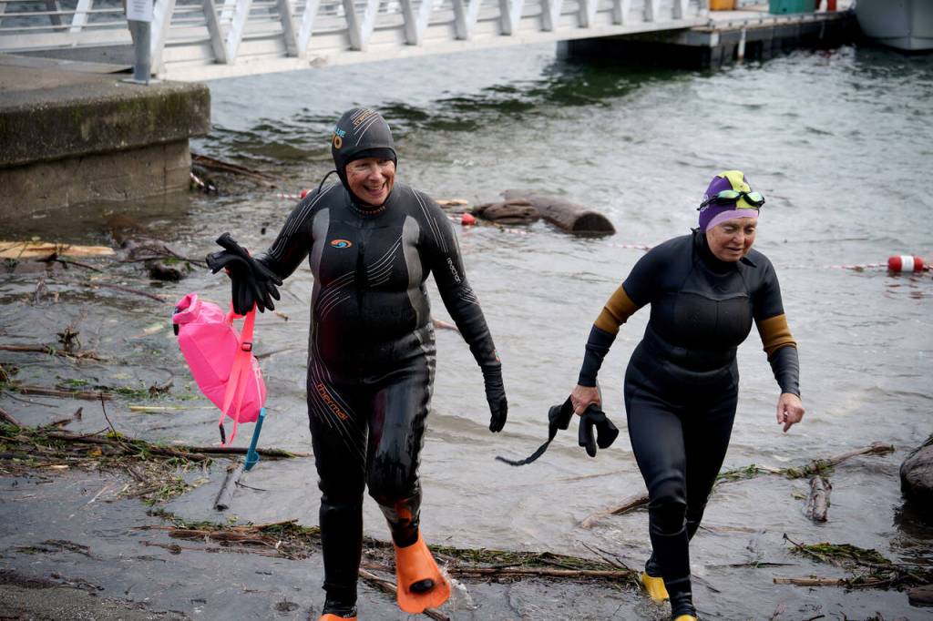 Sharon Emerson and Kate Poss exit from their morning swim at the Langley marina. (Photo by David Welton)