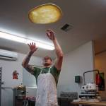 Paul throws some pizza dough up in the air. (Photo by David Welton)