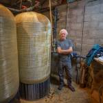 John Lovie, an expert advisor on drinking water, stands near a greensand filtration system inside a well house on SOuth Whidbey. (Photo by David Welton)
