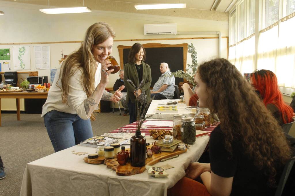 Woodhaven High School teacher Jules LeDrew smells an orange and bergamot candle made by tenth grader Alicia Jenkins. (Photo by Kira Erickson/South Whidbey Record)