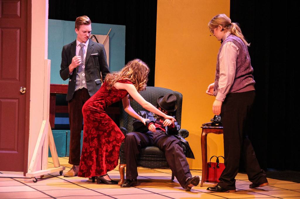Mrs. Scarlet (Isabella Barbee) tries to make the dead motorist (Alyza Doctolero) look like shes sleeping as Mr. Green (Asher Lemme, at left) and Professor Plum (Kincaid Cochran, at right) watch. (Photo by Luisa Loi)