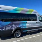The two newest members of the fleet are the E Ford 350EL model Lightning eMotors battery electric vehicles donning the organization’s brand-new design: stripes of green, blue and purple gradients behind simple linework of orcas, homes, trees and sunshine. (Photo courtesy of Island Transit)
